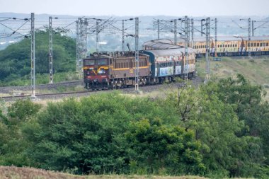 Pune, Hindistan - 24 Ekim 2023: WCAM2P elektrikli lokomotif Pune Hindistan yakınlarındaki bir yolcu trenini taşıyor.
