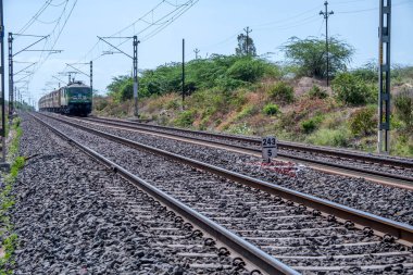 Pune, Hindistan - 11 Haziran 2023: Pune Hindistan yakınlarında WAG9 elektrikli bir lokomotif tarafından taşınan yolcu treni.