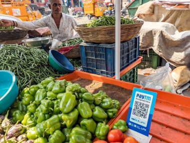 Pune, Hindistan - 30 Ekim 2023: Pune Hindistan 'daki bir sebze tezgahında sebzeler arasında yapılan ödemeler için bir QR kod tarayıcısı yerleştirildi.