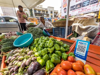 Pune, Hindistan - 30 Ekim 2023: Pune Hindistan 'daki bir sebze tezgahında sebzeler arasında yapılan ödemeler için bir QR kod tarayıcısı yerleştirildi.