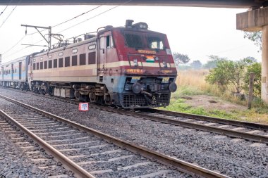 Pune, Hindistan - 05 Kasım 2023: Pune Hindistan yakınlarında WAP4 elektrikli bir lokomotif tarafından taşınan yolcu treni.
