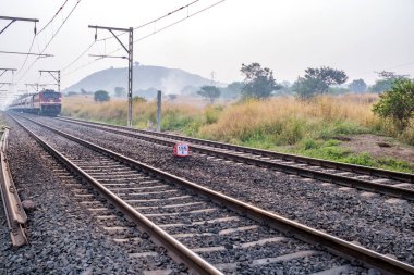 Pune, Hindistan - 05 Kasım 2023: Pune Hindistan yakınlarında WAP4 elektrikli bir lokomotif tarafından taşınan yolcu treni.