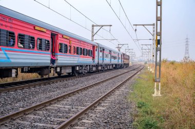 Pune, Hindistan - 05 Kasım 2023: Pune Hindistan yakınlarında WAP4 elektrikli bir lokomotif tarafından taşınan yolcu treni.