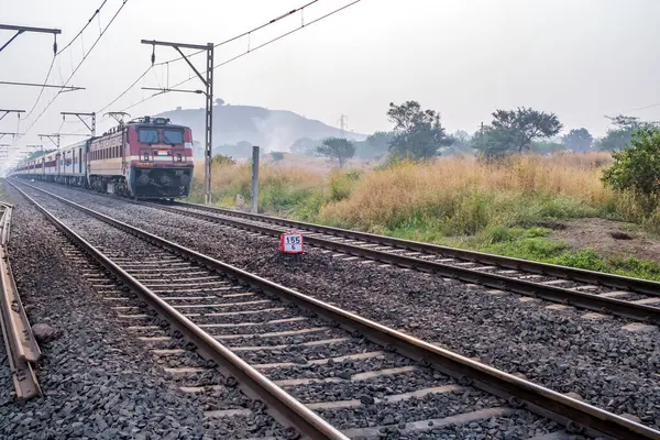 Pune, Hindistan - 05 Kasım 2023: Pune Hindistan yakınlarında WAP4 elektrikli bir lokomotif tarafından taşınan yolcu treni.