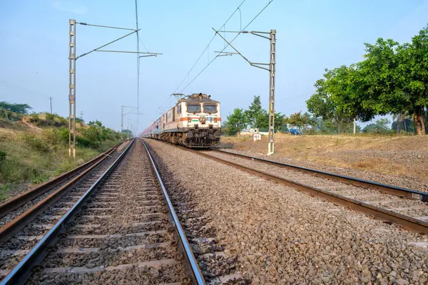 stock image Pune, India - November 13 2023: Passenger train hauled by a WAP7 electric locomotive near Pune India.