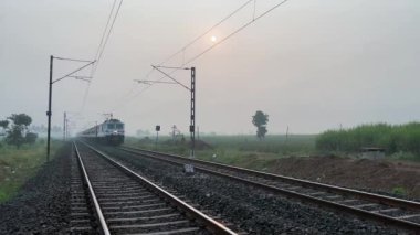 Pune, Hindistan - 19 Kasım 2023: Pune Hindistan yakınlarında WAP7 elektrikli bir lokomotif tarafından taşınan yolcu treni.