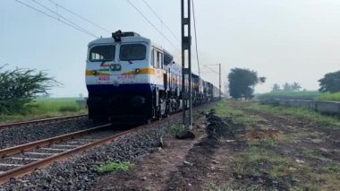 Pune, Hindistan - 19 Kasım 2023: WDP4D dizel lokomotif Pune Hindistan yakınlarındaki bir yolcu trenini taşıyor.
