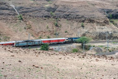 Pune, Hindistan - Haziran 01 2024: WDP4D dizel lokomotif Pune Hindistan yakınlarındaki bir yolcu trenini taşıyor.