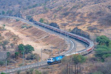 Pune, Hindistan - 01 Mart 2025: WDP4D dizel lokomotif Pune Hindistan yakınlarındaki bir yolcu trenini taşıyor.