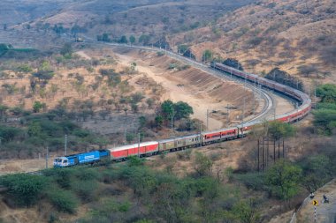 Pune, Hindistan - 01 Mart 2025: WDP4D dizel lokomotif Pune Hindistan yakınlarındaki bir yolcu trenini taşıyor.