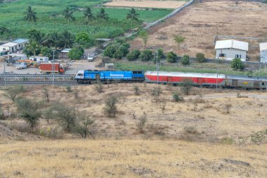 Pune, Hindistan - 01 Mart 2025: WDP4D dizel lokomotif Pune Hindistan yakınlarındaki bir yolcu trenini taşıyor.