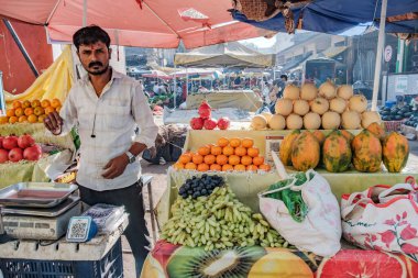 Pune, Hindistan - 09 Mart 2025: Pune India 'daki Mandai pazarında erkek satıcı ve QR kodlu bir sebze tezgahında sahne.