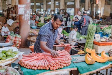 Pune, Hindistan - 09 Mart 2025: Pune India 'daki Mandai pazarında erkek satıcı ve QR kodlu bir sebze tezgahında sahne.