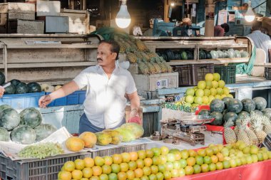 Pune, Hindistan - 09 Mart 2025: Pune India 'daki Mandai pazarında erkek satıcı ve QR kodlu bir sebze tezgahında sahne.