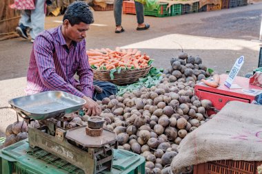 Pune, Hindistan - 09 Mart 2025: Pune India 'daki Mandai pazarında erkek satıcı ve QR kodlu bir sebze tezgahında sahne.