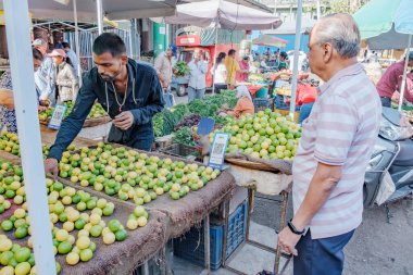 Pune, Hindistan - 09 Mart 2025: Pune India 'daki Mandai pazarında erkek satıcı ve QR kodlu bir sebze tezgahında sahne.
