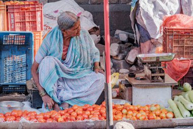 Pune, Hindistan - 09 Mart 2025: Pune India 'daki Mandai pazarında kadın satıcı. Pune şehrinin en büyük perakende sebze pazarı ve 1886 'dan kalma ikonik bir binada bulunuyor..