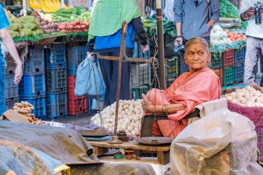 Pune, Hindistan - 09 Mart 2025: Pune India 'daki Mandai pazarında kadın satıcı. Pune şehrinin en büyük perakende sebze pazarı ve 1886 'dan kalma ikonik bir binada bulunuyor..