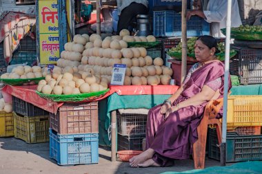 Pune, Hindistan - 09 Mart 2025: Pune India 'daki Mandai pazarında kadın satıcı. Pune şehrinin en büyük perakende sebze pazarı ve 1886 'dan kalma ikonik bir binada bulunuyor..