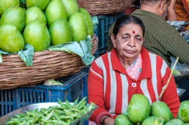 Pune, Hindistan - 09 Mart 2025: Pune India 'daki Mandai pazarında kadın satıcı. Pune şehrinin en büyük perakende sebze pazarı ve 1886 'dan kalma ikonik bir binada bulunuyor..