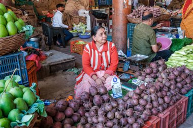 Pune, Hindistan - 09 Mart 2025: Pune India 'daki Mandai pazarında kadın satıcı. Pune şehrinin en büyük perakende sebze pazarı ve 1886 'dan kalma ikonik bir binada bulunuyor..