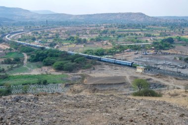Pune, Hindistan - 01 Mart 2025: Pune Hindistan yakınlarında bir WAG9 elektrikli lokomotifi tarafından taşınan bir araba nakliye treni.