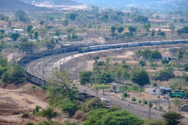 Pune, Hindistan - 01 Mart 2025: Pune Hindistan yakınlarında bir WAG9 elektrikli lokomotifi tarafından taşınan bir araba nakliye treni.