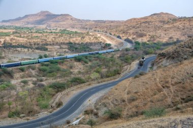 Pune, Hindistan - 01 Mart 2025: Pune Hindistan yakınlarında bir WAG9 elektrikli lokomotifi tarafından taşınan bir araba nakliye treni.