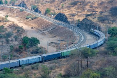 Pune, Hindistan - 01 Mart 2025: Pune Hindistan yakınlarında bir WAG9 elektrikli lokomotifi tarafından taşınan bir araba nakliye treni.