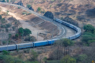 Pune, Hindistan - 01 Mart 2025: Pune Hindistan yakınlarında bir WAG9 elektrikli lokomotifi tarafından taşınan bir araba nakliye treni.