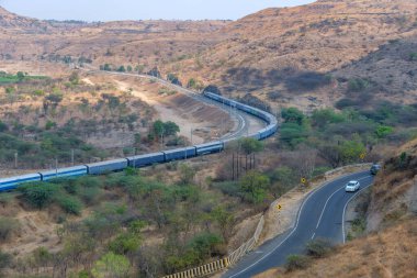 Pune, Hindistan - 01 Mart 2025: Pune Hindistan yakınlarında bir WAG9 elektrikli lokomotifi tarafından taşınan bir araba nakliye treni.