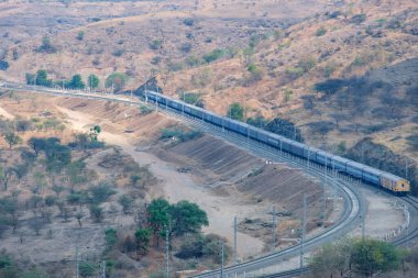 Pune, Hindistan - 01 Mart 2025: Pune Hindistan yakınlarında bir WAG9 elektrikli lokomotifi tarafından taşınan bir araba nakliye treni.