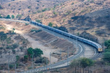 Pune, Hindistan - 01 Mart 2025: Pune Hindistan yakınlarında bir WAG9 elektrikli lokomotifi tarafından taşınan bir araba nakliye treni.
