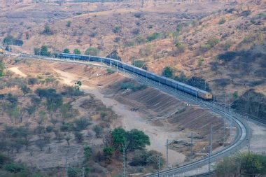 Pune, Hindistan - 01 Mart 2025: Pune Hindistan yakınlarında bir WAG9 elektrikli lokomotifi tarafından taşınan bir araba nakliye treni.