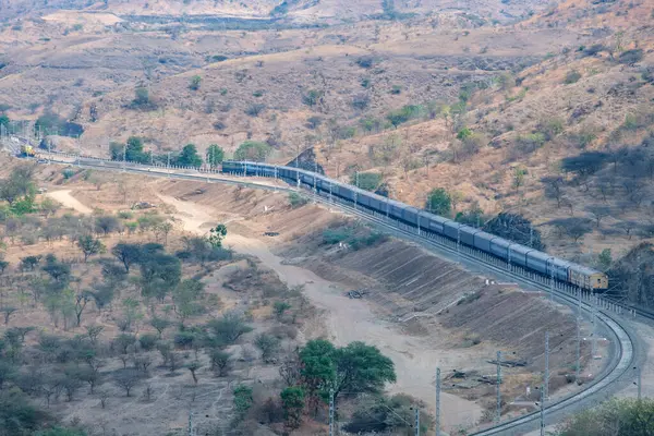 Pune, Hindistan - 01 Mart 2025: Pune Hindistan yakınlarında bir WAG9 elektrikli lokomotifi tarafından taşınan bir araba nakliye treni.