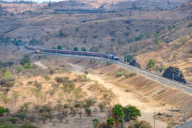 Pune, Hindistan - 01 Mart 2025: WDP4D dizel lokomotif Pune Hindistan yakınlarındaki bir yolcu trenini taşıyor.