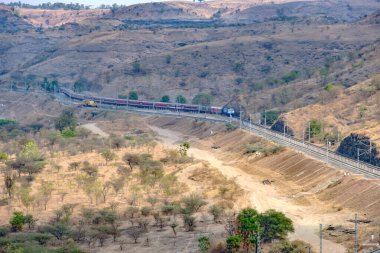 Pune, Hindistan - 01 Mart 2025: WDP4D dizel lokomotif Pune Hindistan yakınlarındaki bir yolcu trenini taşıyor.