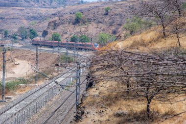 Pune, Hindistan - 22 Mart 2025: Safran renkli Vande Bharat Ekspresi Pune Hindistan yakınlarında. Bu Pune ve Kolhapur arasında üç haftalık bir tren ve ayrıca Pune ve Hubballi arasında üç haftalık bir tren..