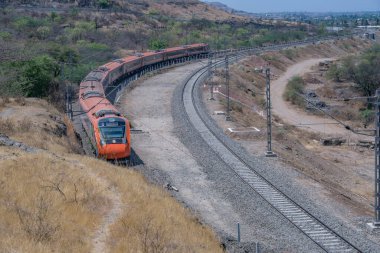 Pune, Hindistan - 22 Mart 2025: Safran renkli Vande Bharat Ekspresi Pune Hindistan yakınlarında. Bu Pune ve Kolhapur arasında üç haftalık bir tren ve ayrıca Pune ve Hubballi arasında üç haftalık bir tren..