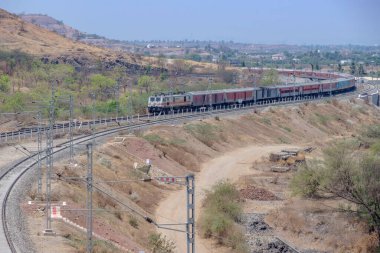 Pune, Hindistan - 22 Mart 2025: Pune Hindistan yakınlarında WAP7 elektrikli bir lokomotif tarafından taşınan yolcu treni.
