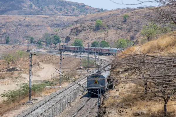 Pune, Hindistan - 22 Mart 2025: Pune Hindistan yakınlarında WAP7 elektrikli bir lokomotif tarafından taşınan yolcu treni.