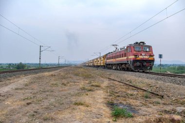 Pune, Hindistan - 31 Mart 2025: Pune Hindistan yakınlarında WAP4 elektrikli bir lokomotif tarafından taşınan yolcu treni.