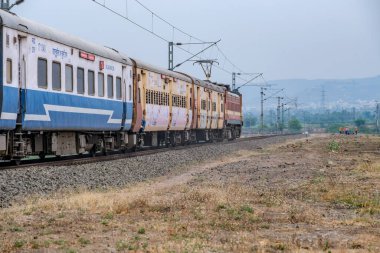 Pune, Hindistan - 31 Mart 2025: Pune Hindistan yakınlarında WAP4 elektrikli bir lokomotif tarafından taşınan yolcu treni.