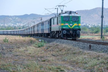 Pune, Hindistan - 12 Nisan 2025: Pune Hindistan yakınlarında bir WAG9 elektrikli lokomotifi tarafından taşınan bir araba nakliye treni.