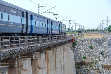 Pune, Hindistan - 12 Nisan 2025: Pune Hindistan yakınlarında bir WAG9 elektrikli lokomotifi tarafından taşınan bir araba nakliye treni.