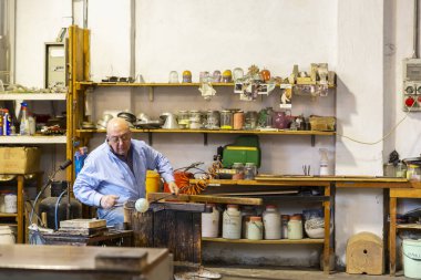 MURANO, İtalya, 20 Şubat 2023: Murano cam fabrikasının içinde, usta bir cam ustası, İtalya 'daki cam üretim sürecini gösteriyor.