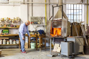 MURANO, İtalya, 20 Şubat 2023: Murano cam fabrikasının içinde, usta bir cam ustası, İtalya 'daki cam üretim sürecini gösteriyor.