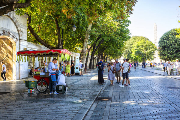 ISTANBUL, TURKEY 2023, August 06: Tourists and vendors in Sultanahmet Park in the Byzantine Hippodrome on a summer day
