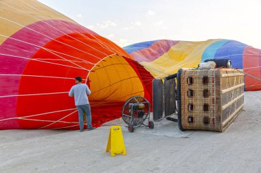 Sıcak hava balonu, alev ve sepet yerde yatarken havayla doluyor ve kalkışa hazırlanıyor, Kapadokya.