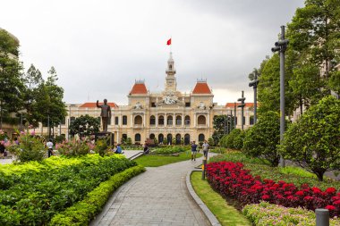 HO CHI MINH CITY, VİETNAM, 17 Ağustos 2024: The Ho Chi Minh Belediye Binası, çevresindeki park ve bahçelerden insanların gezindiği seçkin bir Fransız sömürge tarzı bina